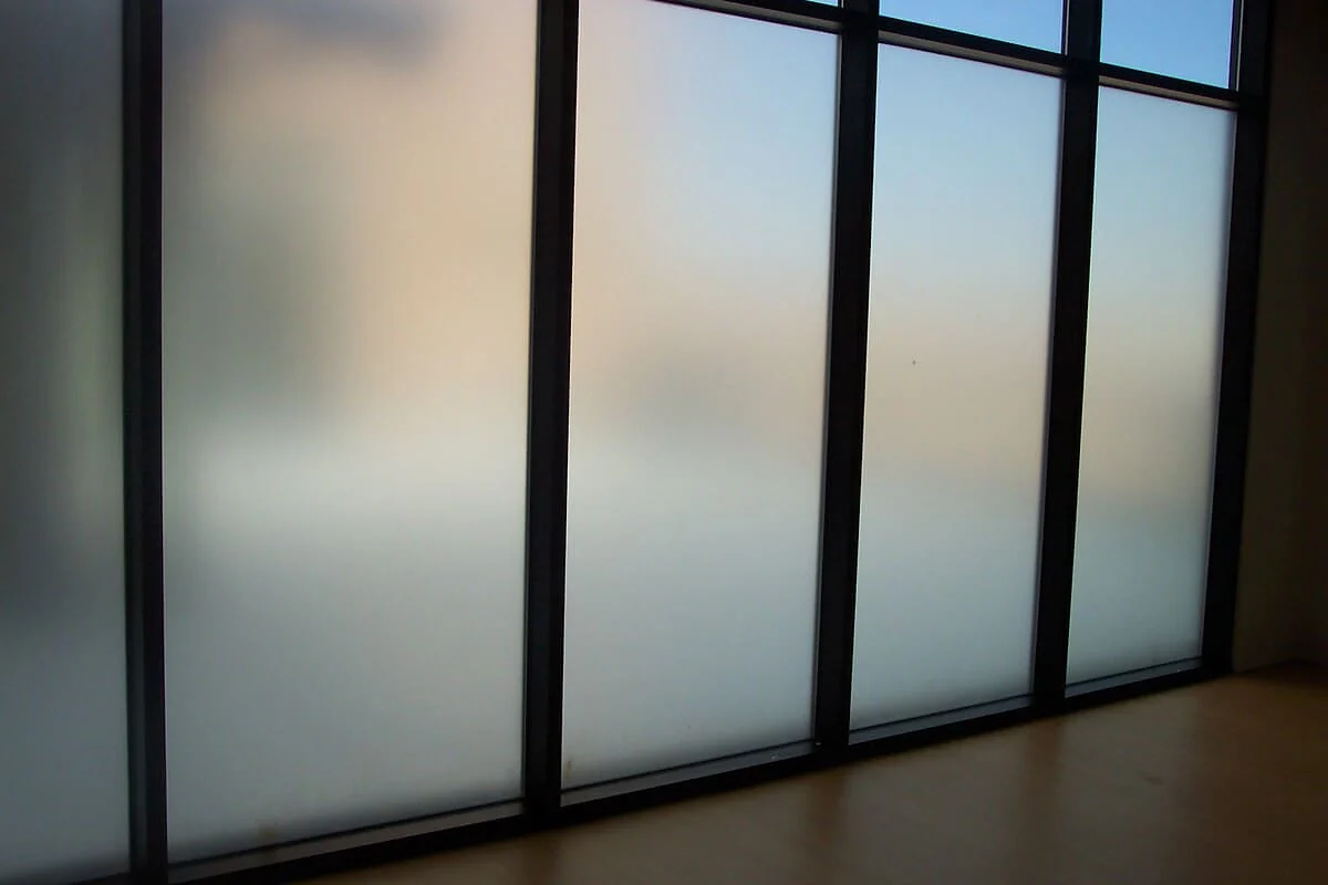 Frosted privacy film on black-framed bathroom glazing